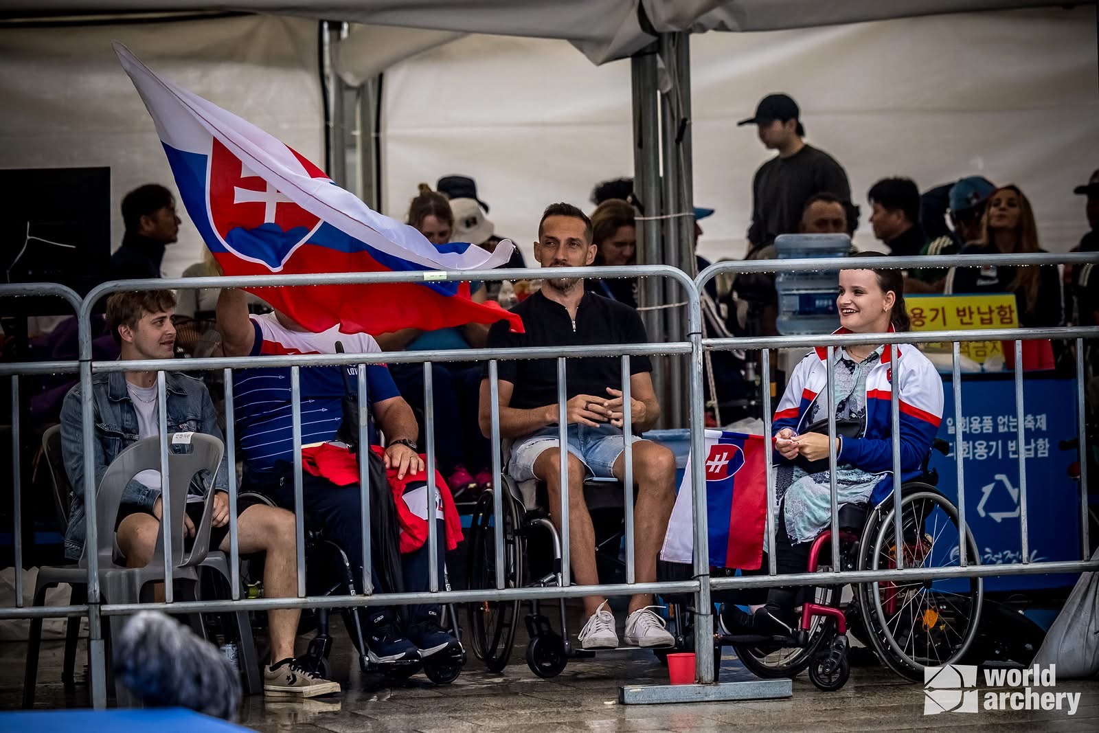 Slovenskí fanúšikovia a členovia reprezentácie so slovenskou vlajkou na medzinárodnej súťaži